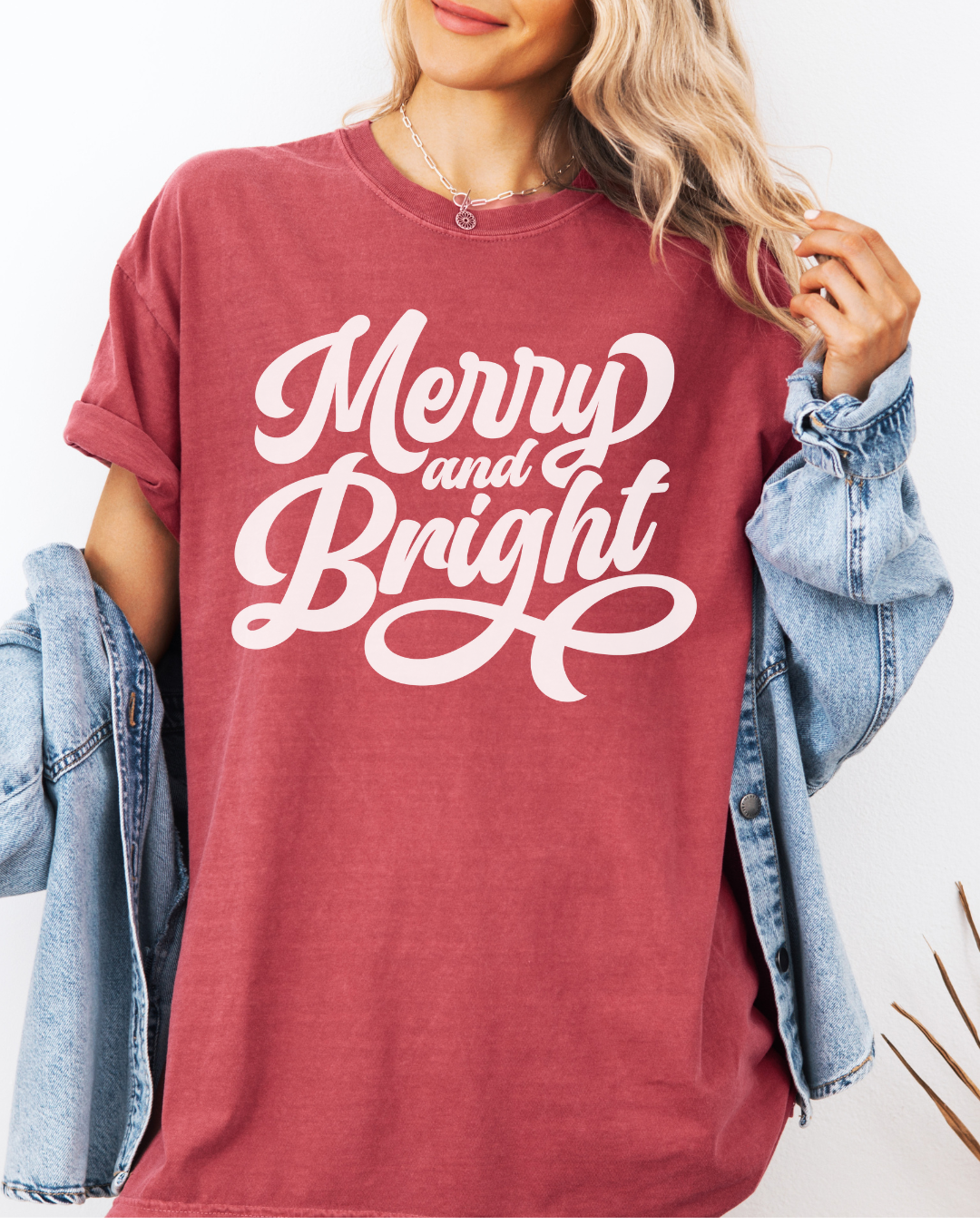 Merry and bright in white writing on a red tee