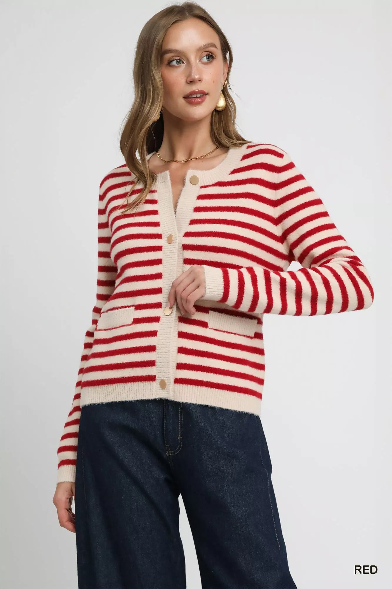 Woman wearing a red and white striped cardigan on a plain background